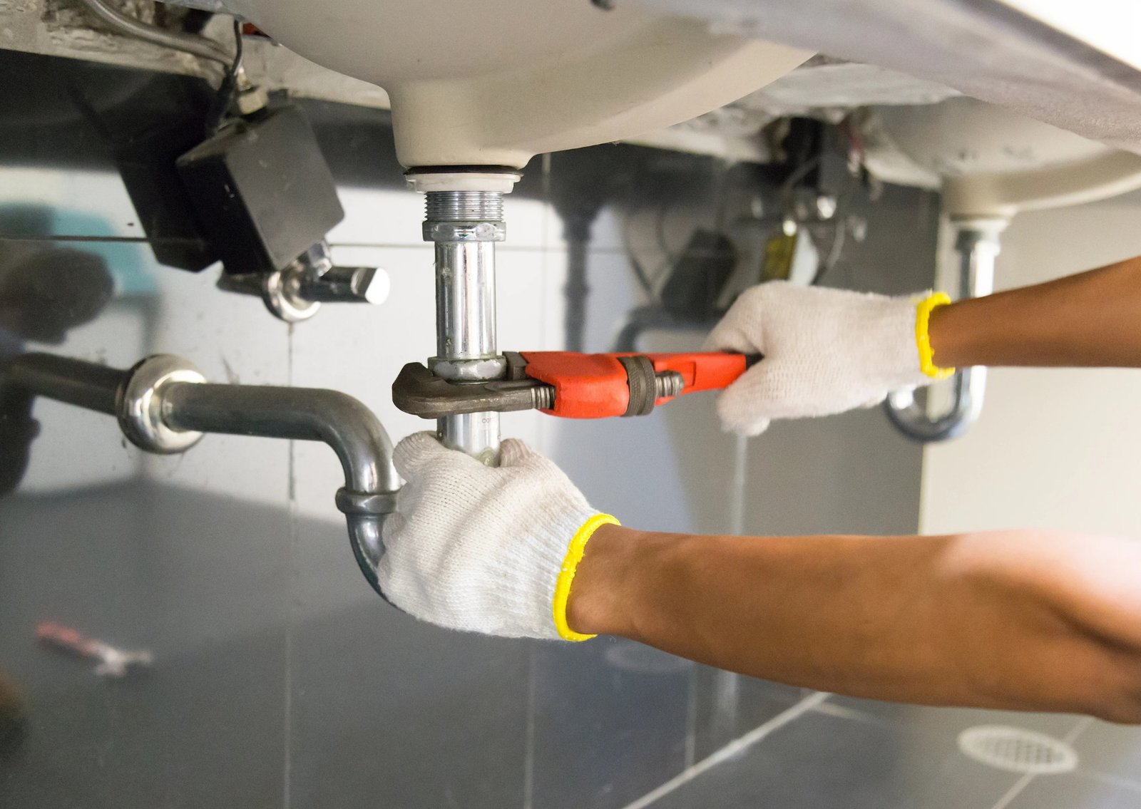 Technician performing plumbing maintenance with professional tools in Ontario
